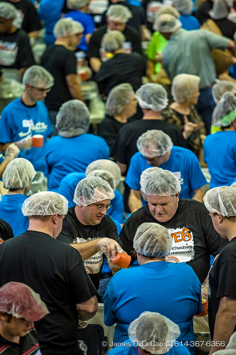 Brian Naess, left, and Steve Hopkins, right, from the Violet Baptist Church and more than 350 other volunteers pack an estimated 80,000 food bags at the Violet Baptist Church Sept. 29. The food bags will be distributed by the Stop Hunger Now organization to more than 70 different countries around the world. (© James D. DeCamp | http://www.JamesDeCamp.com | 614-367-6366)