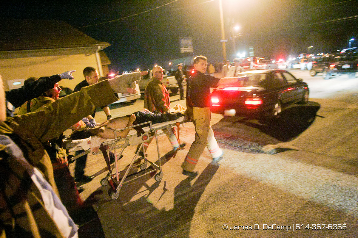 Columbus, Worthington & Clinton Twp Medics transport one of seven shooting victims at the Alrosa Villa, 5055 Sinclair Road late Wednesday night December 8, 2004. (© James D. DeCamp | http://www.JamesDeCamp.com | 614-367-6366)