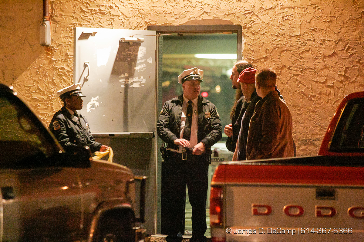 Columbus Police guard the doors from the parking lot as Columbus, Worthington & Clinton Twp Medics work on one of seven shooting victims at the Alrosa Villa, 5055 Sinclair Road late Wednesday night December 8, 2004. (© James D. DeCamp | http://www.JamesDeCamp.com | 614-367-6366)