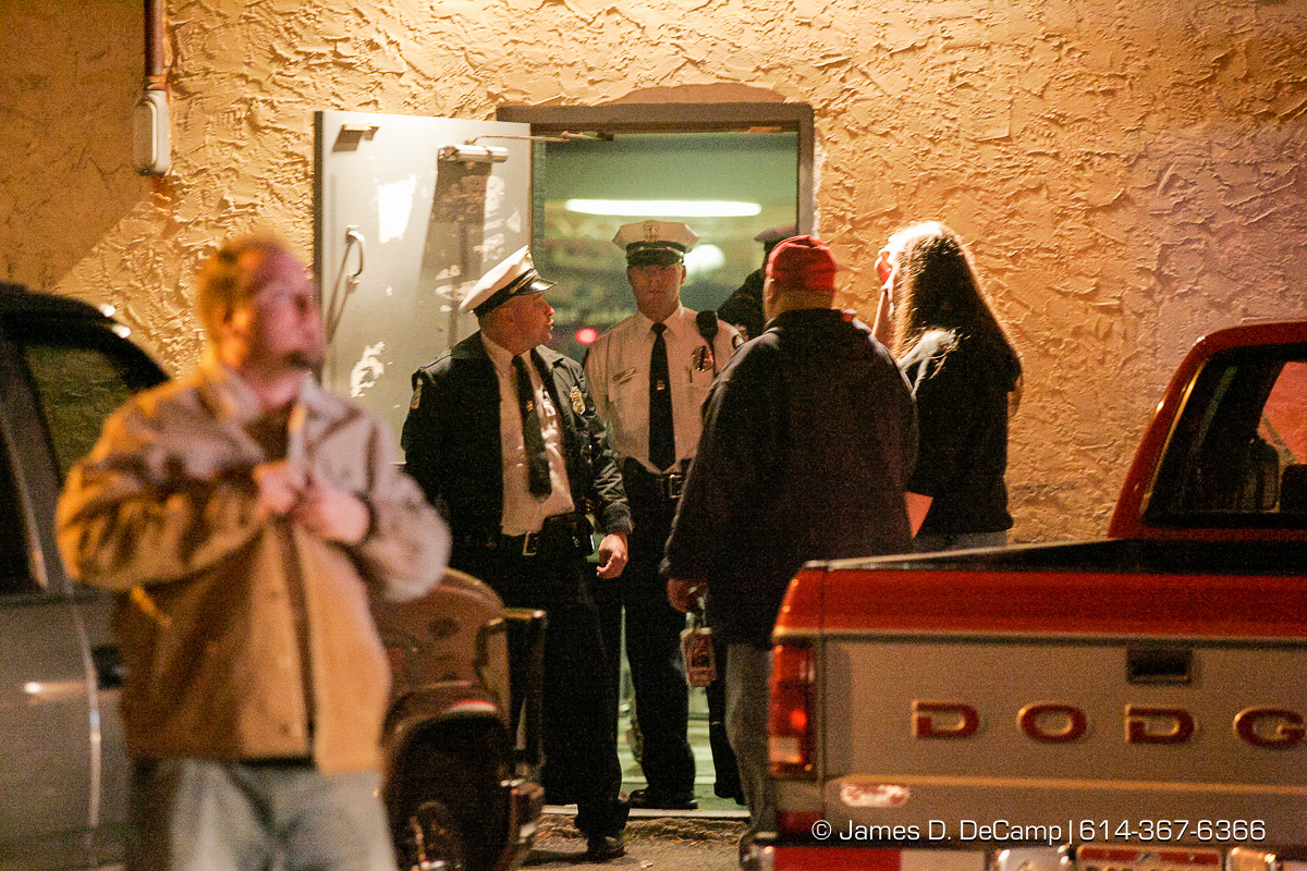 Columbus Police guard the doors from the parking lot as Columbus, Worthington & Clinton Twp Medics work on one of seven shooting victims at the Alrosa Villa, 5055 Sinclair Road late Wednesday night December 8, 2004. (© James D. DeCamp | http://www.JamesDeCamp.com | 614-367-6366)