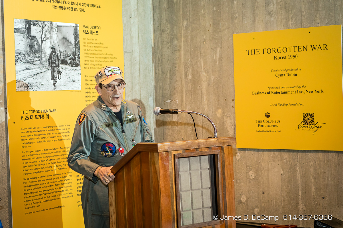 The ribbon cutting of The Forgotten War, Korea 1950, Photographs by Max Desfor photographed Friday, November 11, 2016 at the Ohio History Center. The Ohio History Center has the honor of presenting, for the first time ever in the United States, THE FORGOTTEN WAR, Korea 1950, Photographs by Max Desfor. The extraordinary exhibit of Korean War photographs taken by Pulitzer Prize-winning Associated Press photographer Max Desfor who spent three turbulent years in Korea from 1950–1953. He captured the people’s plight and the American soldiers’ defense. The exhibit features 36 photographs printed from original material culled from Desfor’s personal collection and his 1950 winning submission to the Pulitzer Prize Committee. Curated and produced by Cyma Rubin. Sponsored and presented by Business of Entertainment Inc., New York. Local funding provided by the Gordon Chandler Memorial Fund of The Columbus Foundation and Conestoga, a volunteer fundraising support group. (© James D. DeCamp | http://JamesDeCamp.com | 614-367-6366)