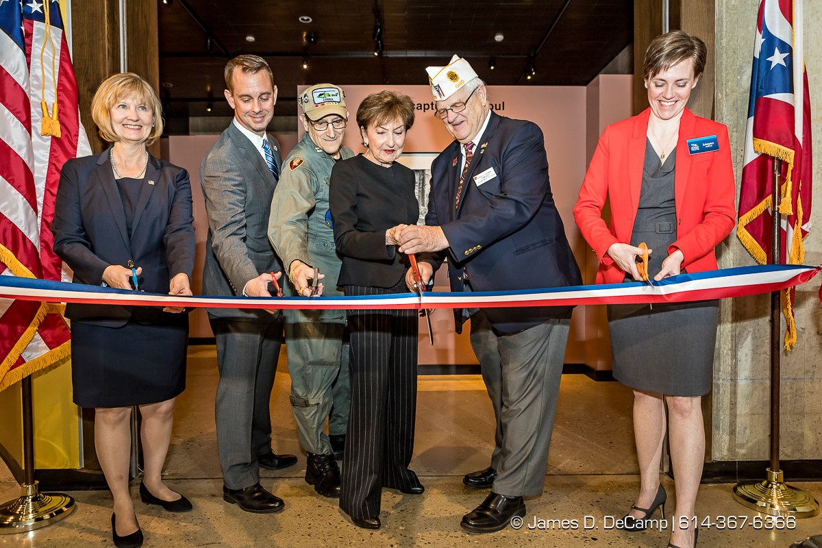 The ribbon cutting of The Forgotten War, Korea 1950, Photographs by Max Desfor photographed Friday, November 11, 2016 at the Ohio History Center. The Ohio History Center has the honor of presenting, for the first time ever in the United States, THE FORGOTTEN WAR, Korea 1950, Photographs by Max Desfor. The extraordinary exhibit of Korean War photographs taken by Pulitzer Prize-winning Associated Press photographer Max Desfor who spent three turbulent years in Korea from 1950–1953. He captured the people’s plight and the American soldiers’ defense. The exhibit features 36 photographs printed from original material culled from Desfor’s personal collection and his 1950 winning submission to the Pulitzer Prize Committee. Curated and produced by Cyma Rubin. Sponsored and presented by Business of Entertainment Inc., New York. Local funding provided by the Gordon Chandler Memorial Fund of The Columbus Foundation and Conestoga, a volunteer fundraising support group. (© James D. DeCamp | http://JamesDeCamp.com | 614-367-6366)