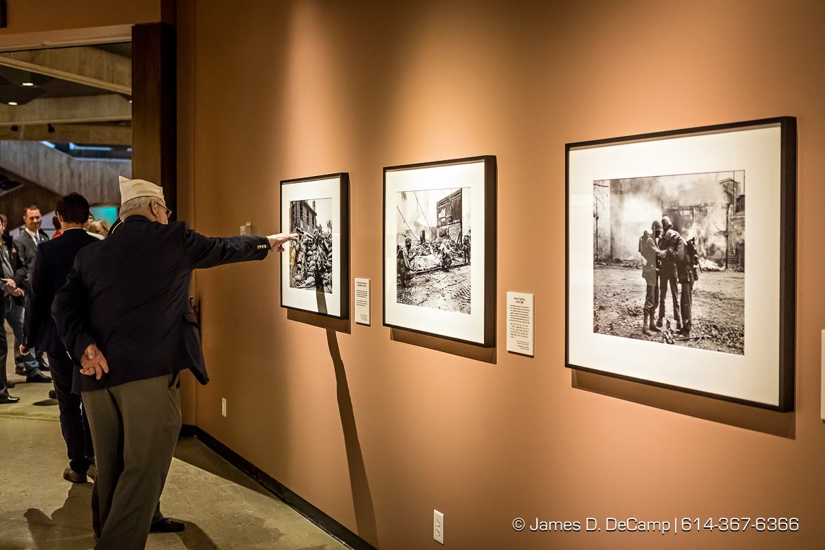 The ribbon cutting of The Forgotten War, Korea 1950, Photographs by Max Desfor photographed Friday, November 11, 2016 at the Ohio History Center. The Ohio History Center has the honor of presenting, for the first time ever in the United States, THE FORGOTTEN WAR, Korea 1950, Photographs by Max Desfor. The extraordinary exhibit of Korean War photographs taken by Pulitzer Prize-winning Associated Press photographer Max Desfor who spent three turbulent years in Korea from 1950–1953. He captured the people’s plight and the American soldiers’ defense. The exhibit features 36 photographs printed from original material culled from Desfor’s personal collection and his 1950 winning submission to the Pulitzer Prize Committee. Curated and produced by Cyma Rubin. Sponsored and presented by Business of Entertainment Inc., New York. Local funding provided by the Gordon Chandler Memorial Fund of The Columbus Foundation and Conestoga, a volunteer fundraising support group. (© James D. DeCamp | http://JamesDeCamp.com | 614-367-6366)
