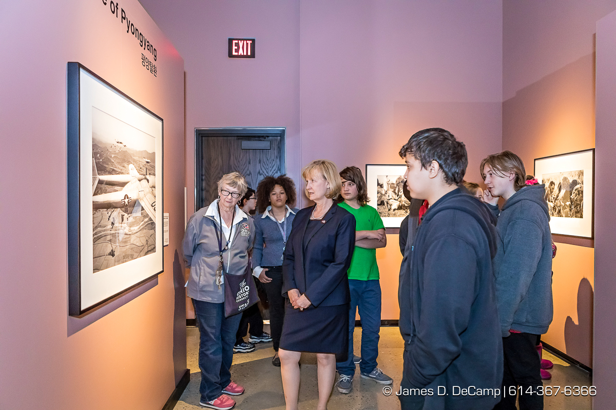 The ribbon cutting of The Forgotten War, Korea 1950, Photographs by Max Desfor photographed Friday, November 11, 2016 at the Ohio History Center. The Ohio History Center has the honor of presenting, for the first time ever in the United States, THE FORGOTTEN WAR, Korea 1950, Photographs by Max Desfor. The extraordinary exhibit of Korean War photographs taken by Pulitzer Prize-winning Associated Press photographer Max Desfor who spent three turbulent years in Korea from 1950–1953. He captured the people’s plight and the American soldiers’ defense. The exhibit features 36 photographs printed from original material culled from Desfor’s personal collection and his 1950 winning submission to the Pulitzer Prize Committee. Curated and produced by Cyma Rubin. Sponsored and presented by Business of Entertainment Inc., New York. Local funding provided by the Gordon Chandler Memorial Fund of The Columbus Foundation and Conestoga, a volunteer fundraising support group. (© James D. DeCamp | http://JamesDeCamp.com | 614-367-6366)